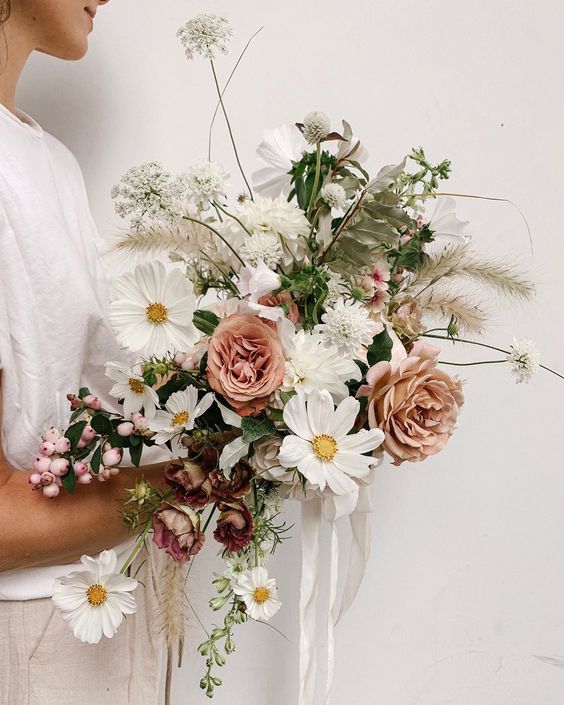 a catchy wedding bouquet of white cosmos, dusty pink roses, lots of grasses, greeneyr and other fillers is a bold and cool idea