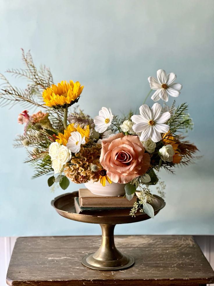 a catchy wedding centerpiece of white cosmos, a pink rose, yellow blooms and greenery is a chic idea for summer