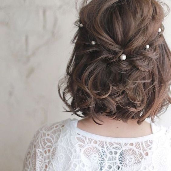 a classic half updo with a messy bump on top, a braided halo with pearls and some waves down