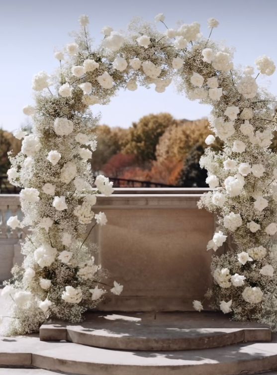 a classic white wedding arch done with white baby's breath and roses is a cool idea for a spring and summer
