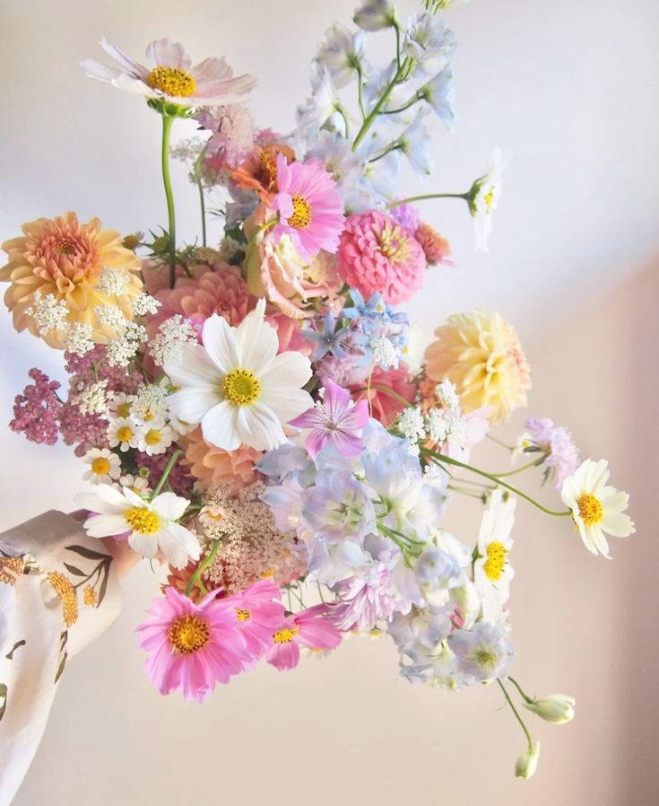 a colorful wedding bouquet of pink and white cosmos, orange dahlias, pink mums and some sweet peas is a cool idea for summer