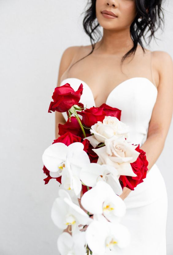 a contrasting cascading wedding bouquet of white and red roses and white orchids is adorable for a wedding