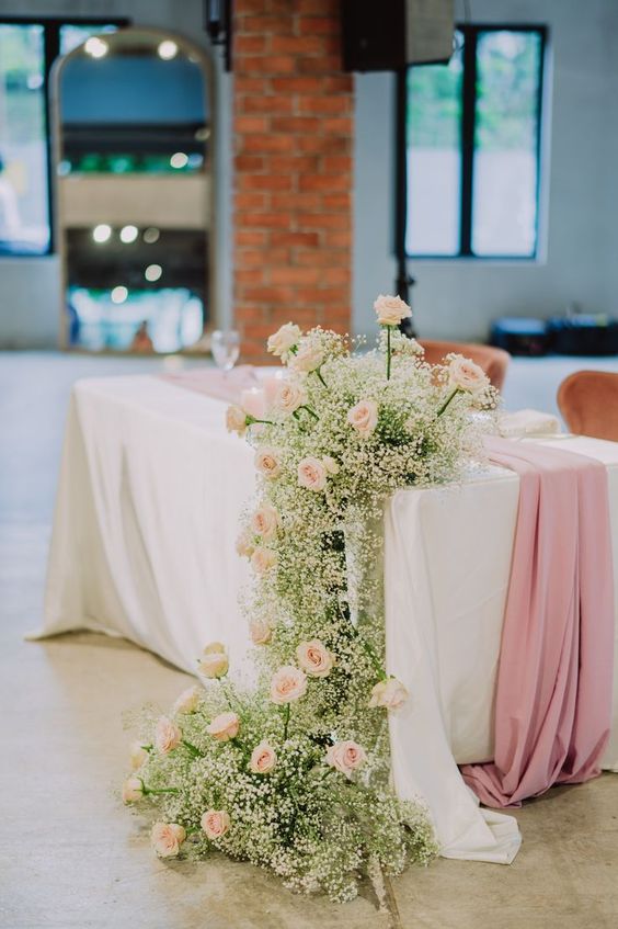 a cool corner cascading wedding centerpiece of blush roses and baby’s breath is a cool and lovely decoration