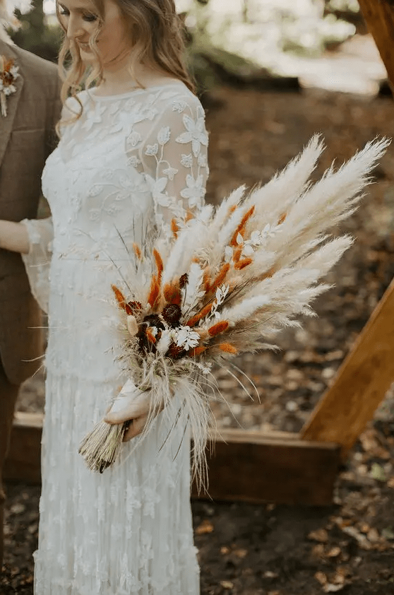 a cool fall wedding bouquet of dried bunny tails, pampas grass, blooms and grasses, neutral or spray painted for a fall boho bride