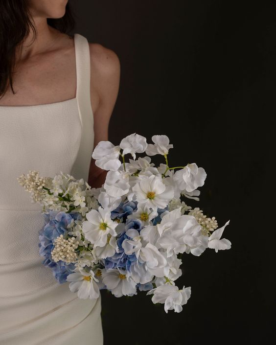 a cool modern wedding bouquet of blue hydrangeas, white sweet peas and cosmos is a cool idea for a modern wedding