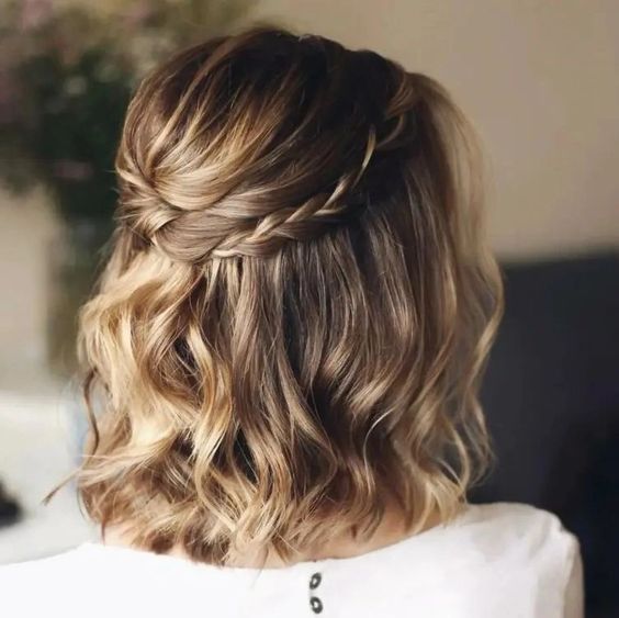 a creative half updo with a bump, a twisted plus braided halo and waves down is a cool hairstyle to try for a wedding