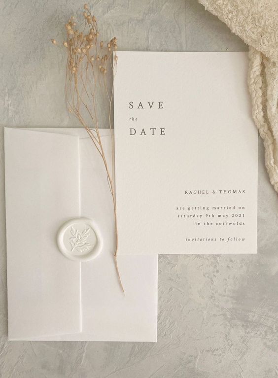 a delicate and ethereal white wedding invitation suit with modern lettering and a white seal is very beautiful