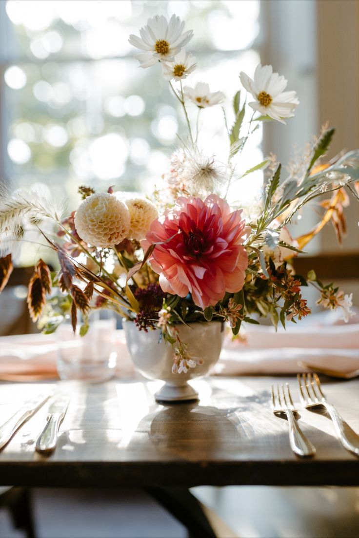 a dimensional wedding centerpiece of white mums and cosmos, grasses and a pink dahlia is a cool idea for summer