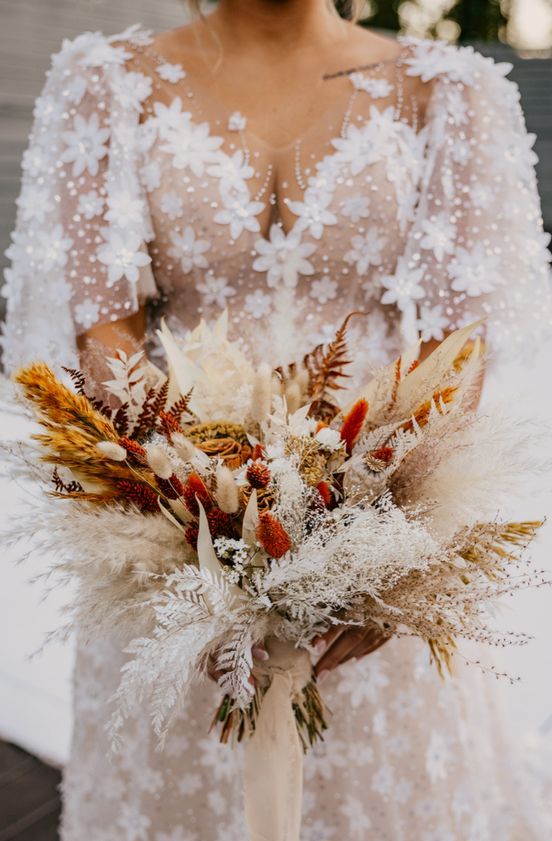 a dried flower wedding bouquet of pampas grass, leaves, bunny tails and other textural stuff is amazing