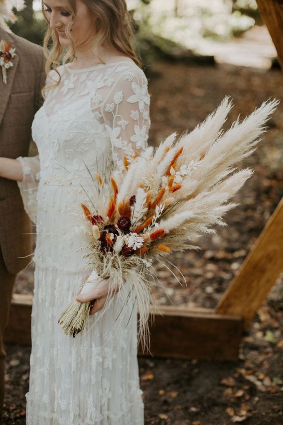 a dried flower wedding bouquet of pampas grass, orange bunny tails, some leaves and bold dried blooms is amazing