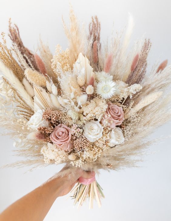 a dried wedding bouquet of pink and white roses, dried blooms, grasses is a cool idea for a summer boho wedding