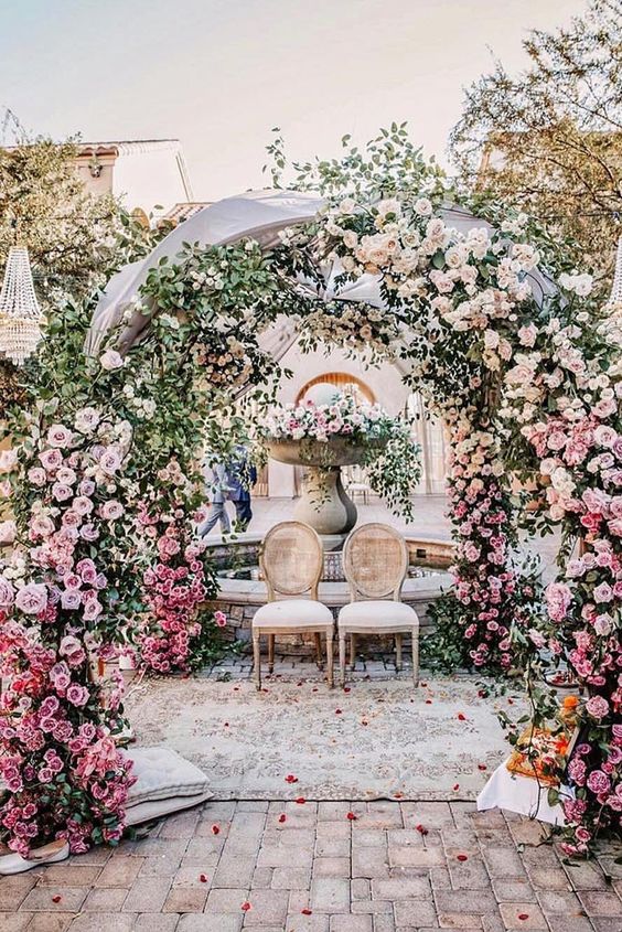 a fantastic ombre wedding arch from pink to blush, with green vines, is a stunning idea for a spring or summer wedding