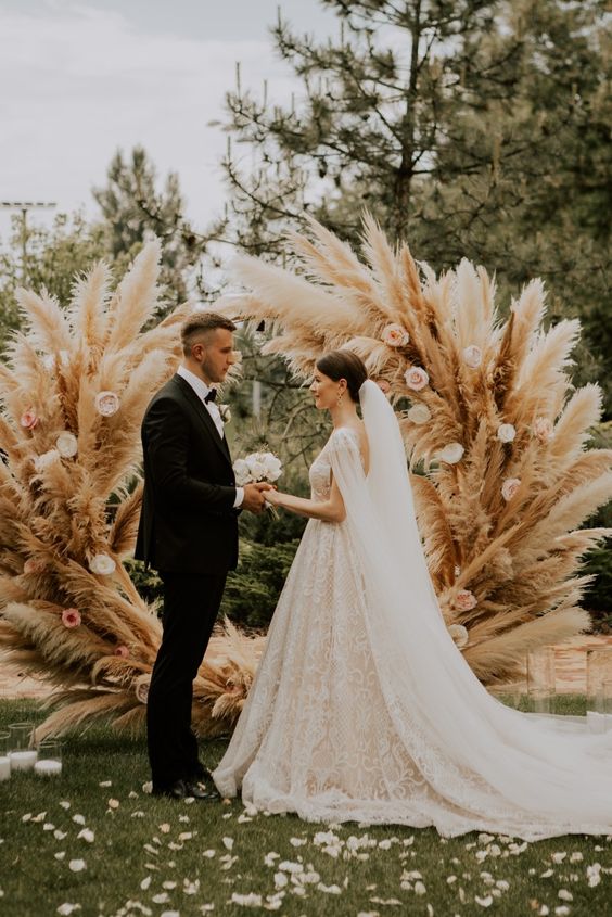 a fantastic pampas grass wedding altar with pink roses is a gorgeous idea for a summer boho wedding