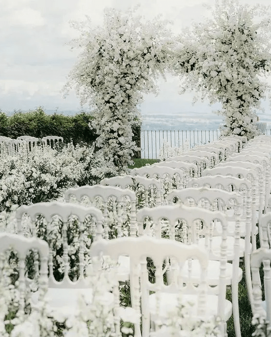 A gorgeous all white wedding arch covered with a lot of blooms and a matching wedding aisle will make your ceremony unforgettable