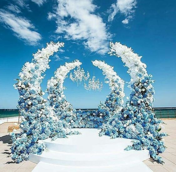a gorgeous luxurious ombre wedding altar from blue to white, with crystal chandeliers is amazing for a refined modern wedding at the seaside