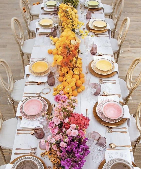a gradient wedding centerpiece from purple to pink and yellow, with citrus and bold blooms is wow for a summer wedding