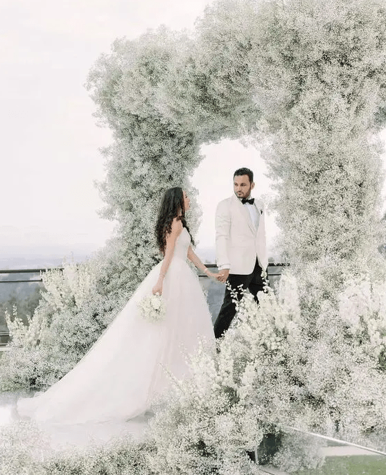 A jaw dropping wedding arch that feels like a cloud as it's fully covered with white baby's breath is amazing