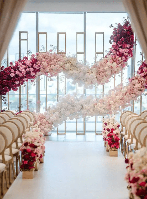 a jaw-dropping wedding backdrop made of ombre garlands of blooms is a gorgeous idea to make a statement in your ceremony space