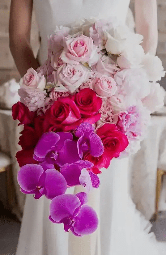 A jaw dropping wedding bouquet from white to light pink, fuchsia and bold purple and a cascading effect is a bright idea