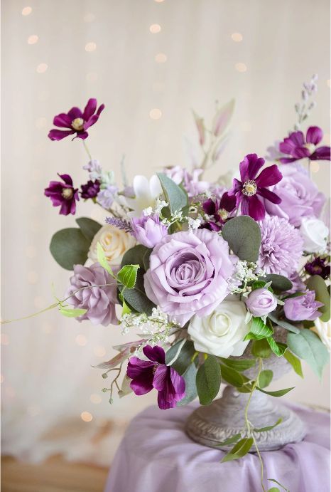 a lilac wedding centerpiece of purple cosmos, lilac roses and dahlias, greenery and grasses is lovely for spring and summer