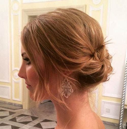 a lovely messy updo with a bump on top and face-framing hair is a stylish and refined wedding hairstyle for short hair