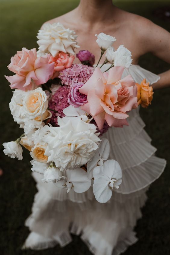 a lovely modern wedding bouquet of white and blush roses, white orchids is a cool and catchy idea for a modern wedding