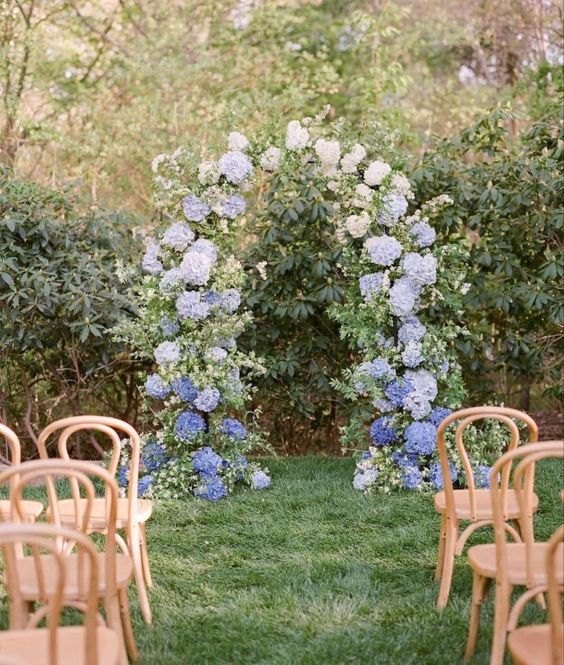 a lovely ombre wedding arch from navy to light blue, with greenery, is a cool idea for a spring or summer wedding