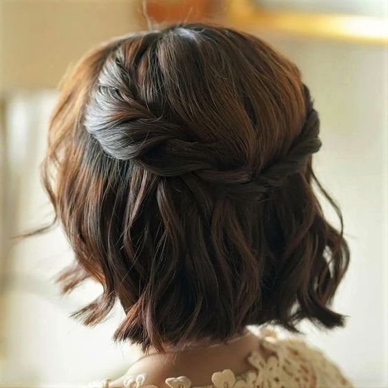 a lovely short half updo with a braided halo and a bump on top plus waves down is amazing for a wedding