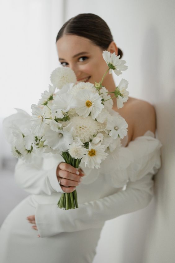 a lovely white wedding bouquet of cosmos and mums is a cool idea for any neutral or all-white wedding