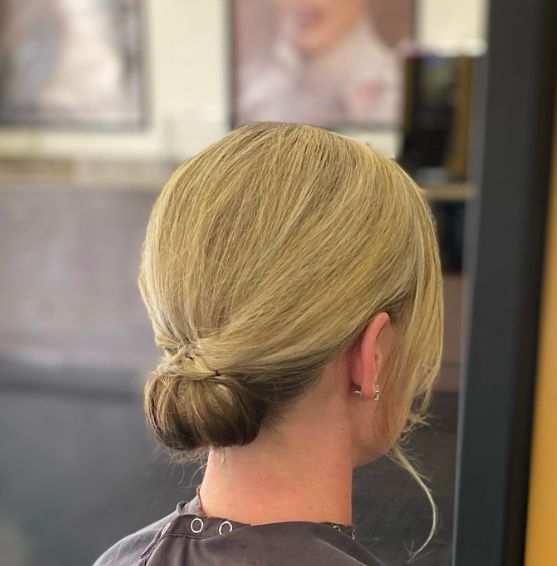 a low bun with a sleek top and face-framing hair is a chic and timeless hairstyle for a wedding, it will work on medium and short hair