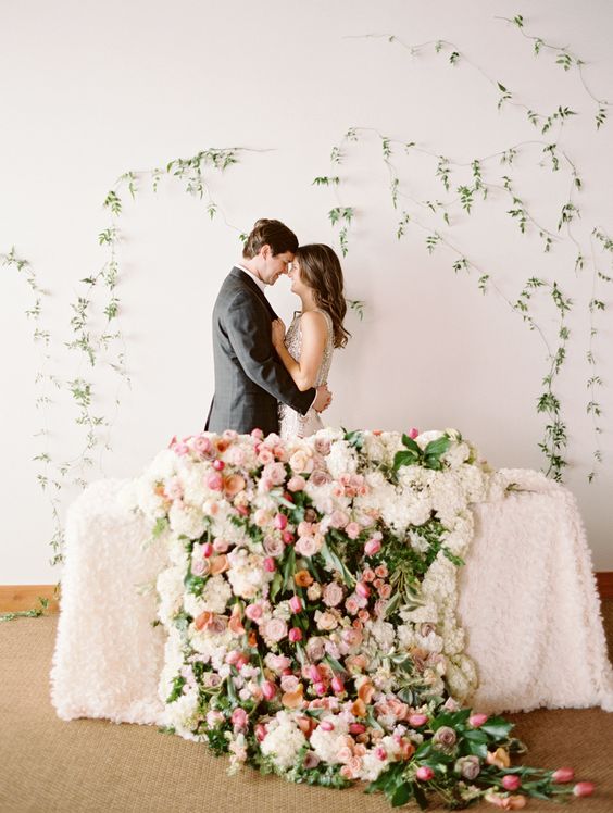 a lush cascading wedding centerpiece of white hydrangeas, pink and blush roses and greenery is amazing