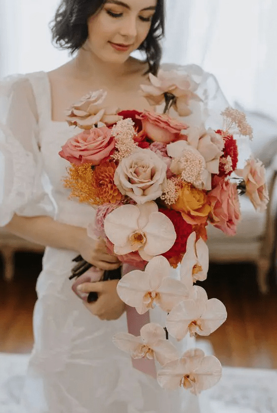 a lush wedding bouquet of pink and blush roses, mums and cascading blush orchids is amazing