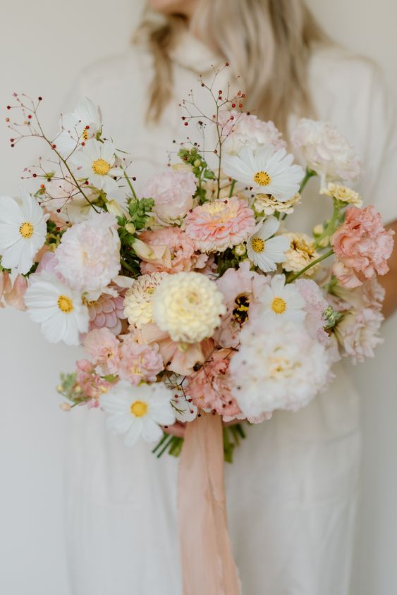 a lush wedding bouquet of white cosmos, pink and yellow mums, some branches and blush ribbons is a cool solution for spring or summer