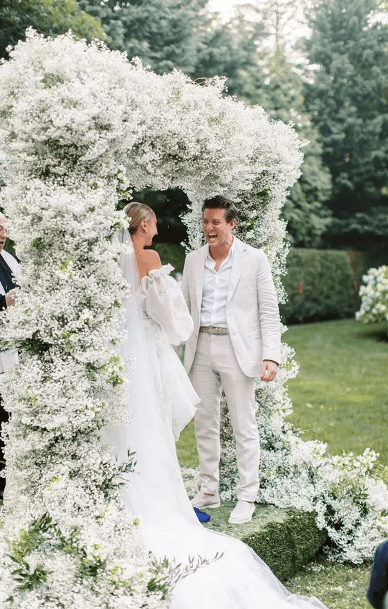 a lush white baby's breath wedding arch is a perfect idea for a modern wedding, this is a classic color