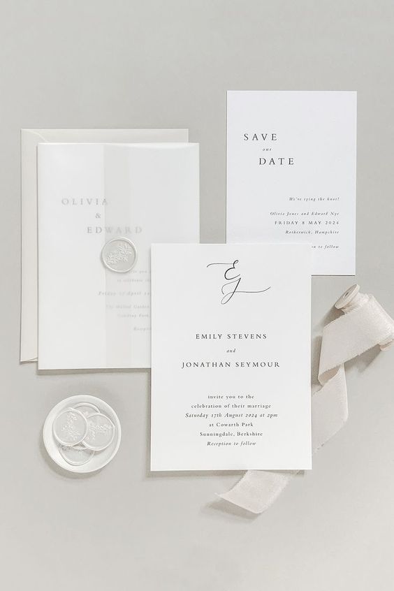 a minimal white wedding invitation suite with a vellum cover, black letters and calligraphy monograms is amazing