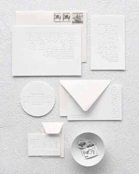 A minimalist all white letterpressed invitation suite is a unique and very eye catchy idea