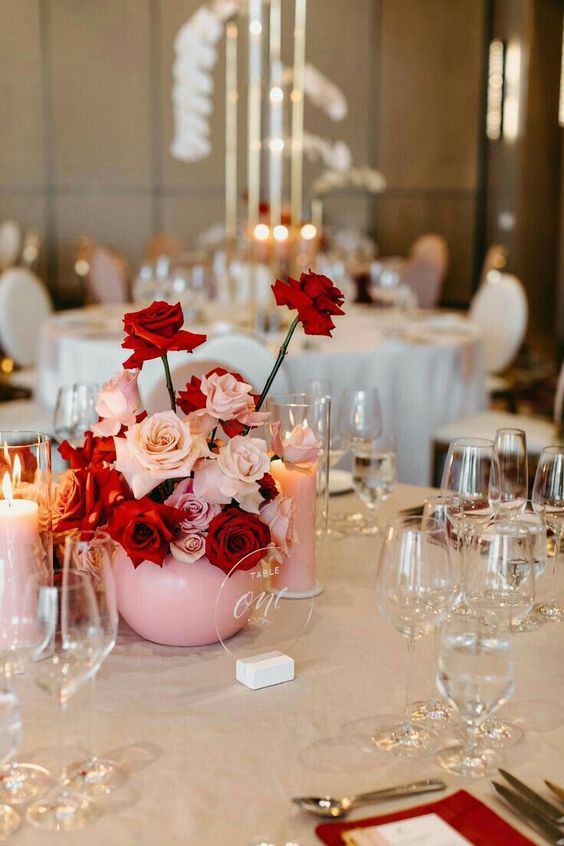 a modern contrasting wedding centerpiece of red and blush roses is a very eye-catchy and bright solution