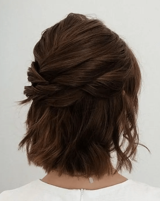a modern half updo with several twists on top and a bump, with some waves down is a cool idea for a bride or bridesmaid