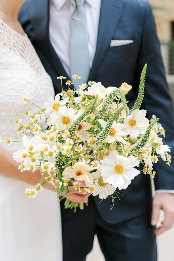 a modern white wedding bouquet of cosmos, chamomiles and astilbe is a chic idea for spring and summer