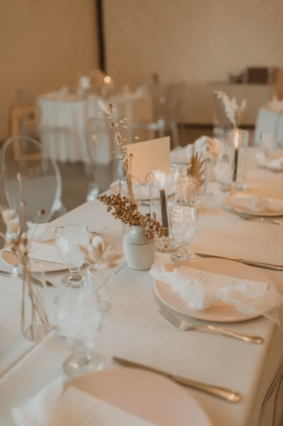 a natural and minimalist wedding table setting with all neutral everything, dried blooms, berries and grey candles is a stylish idea