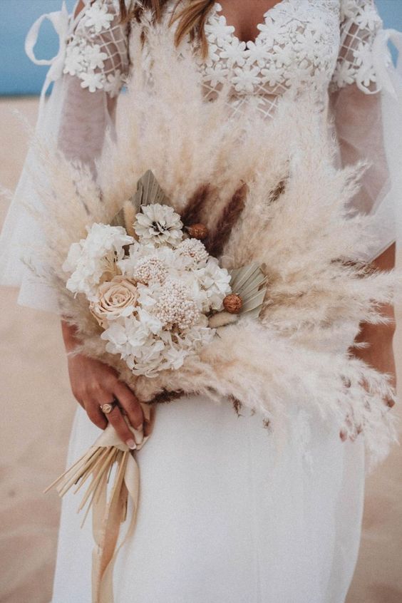 a neutral boho wedding bouquet of pampas grass, blush roses and white hydrangeas, fronds is a cool solution