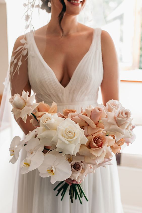 a neutral wedding bouquet of blush and white roses and white orchids is a stylish and catchy idea