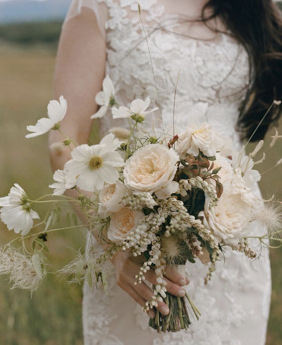 a neutral wedding bouquet of ranunculus, cosmos, berries and grasses is a cool idea for a modern wedding