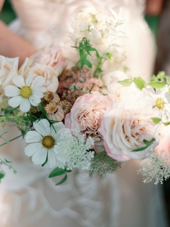 a neutral wedding bouquet of white cosmos, blush roses and seed pods is a catchy idea for spring and summer