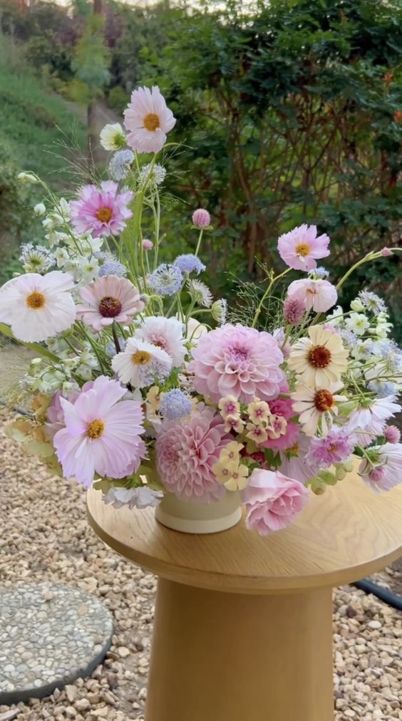 a pink wedding centerpiece of dahlias, cosmos and pink and blue fillers is a cool idea for spring or summer