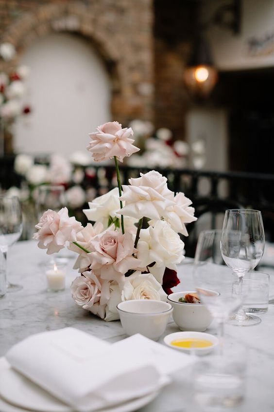 a pretty modern blush and white rose wedding centerpiece is a stunning and chic decoration for a modern wedding