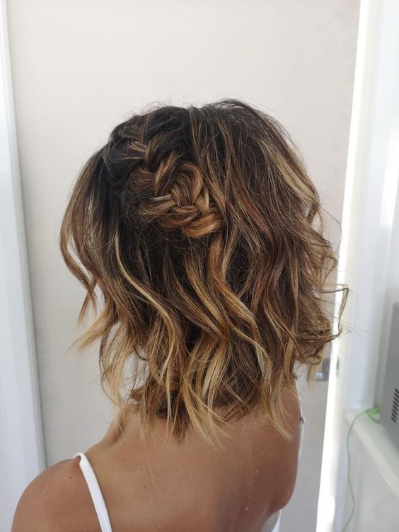 a pretty short half updo with a loose braid on one side and wavy hair down plus a lot of volume is wow