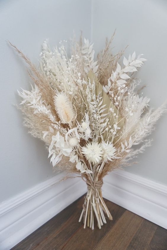 a pure white wedding bouquet of pampas grass and dried leaves and grasses is amazing for a boho wedding