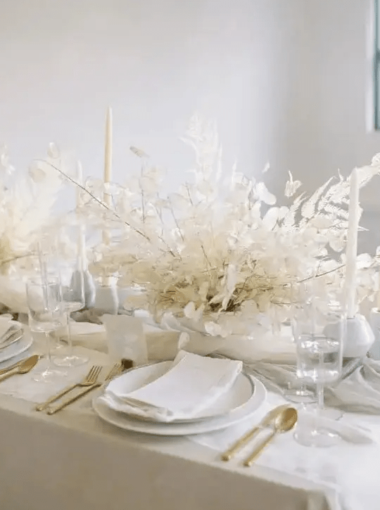 A really ethereal dried leaf wedding centerpiece with lunaria is ideal for an all white wedding tablescape and it looks chic and elegant