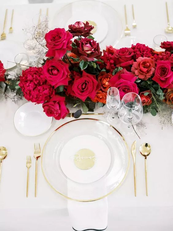 a refined and bold wedding centerpiece of red roses and burgundy peonies, greenery and some fillers is amazing for a bright wedding